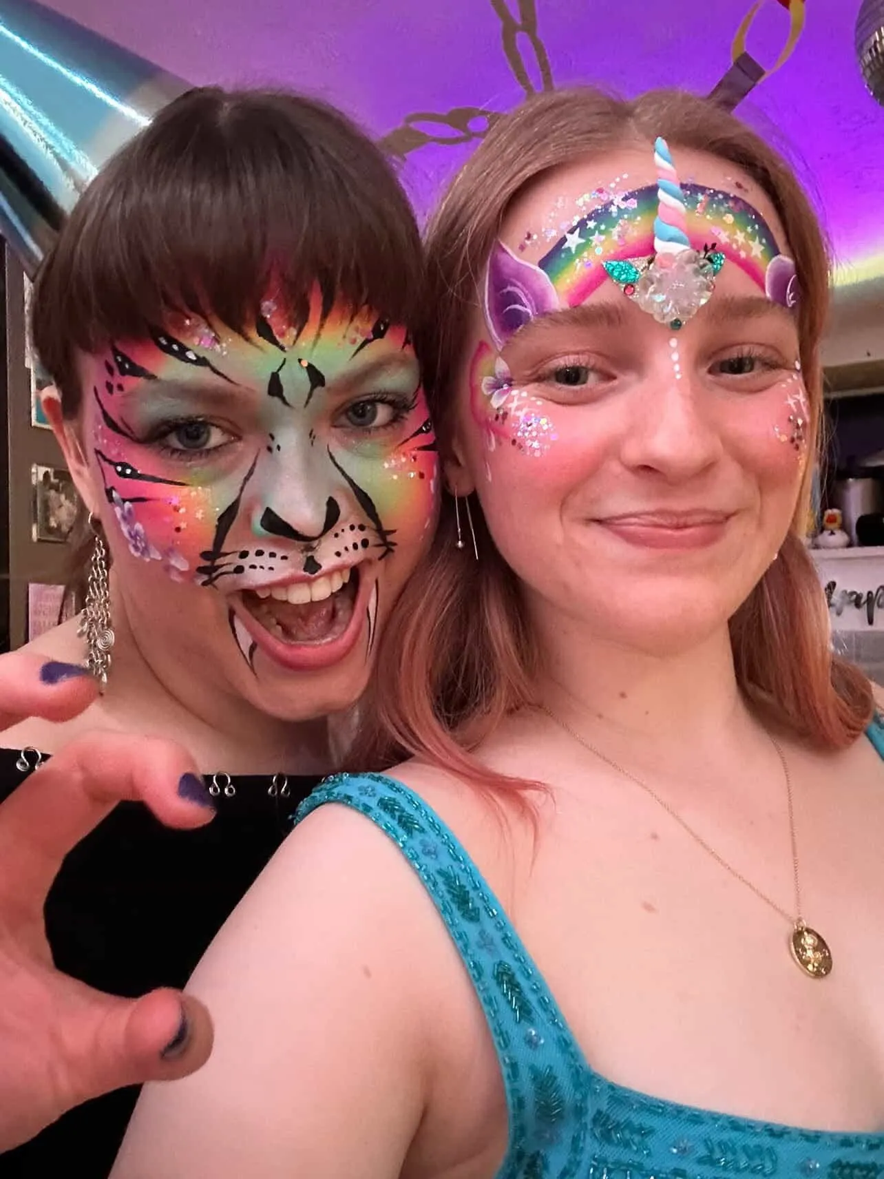 Two friends with glitter face designs at a party