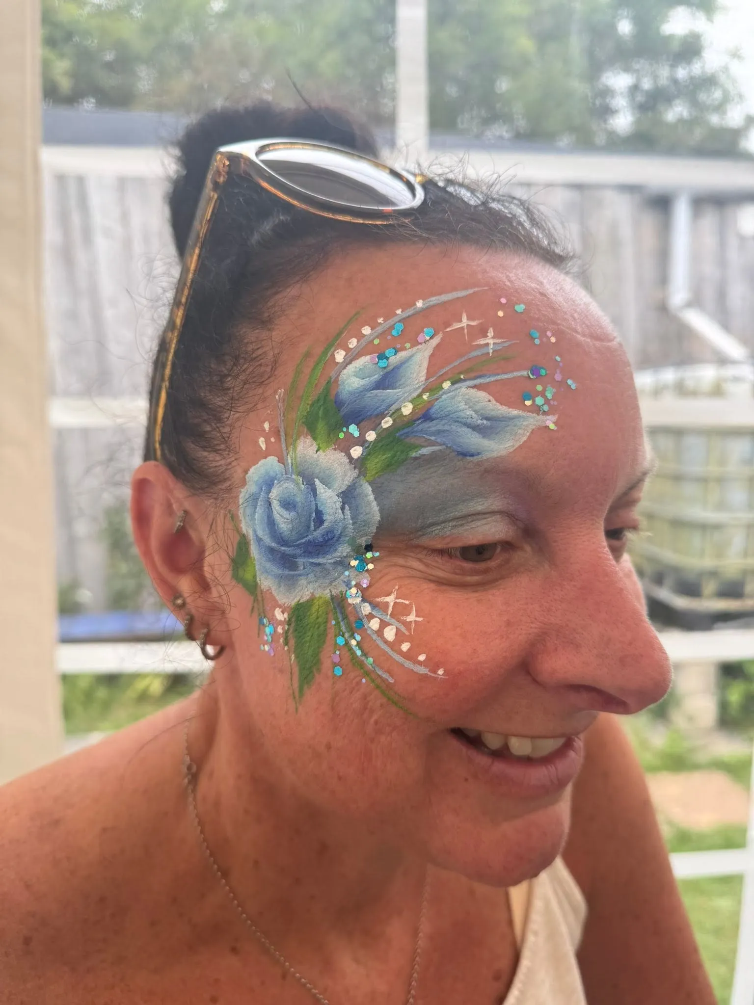 Woman with a blue rose and glitter eye design