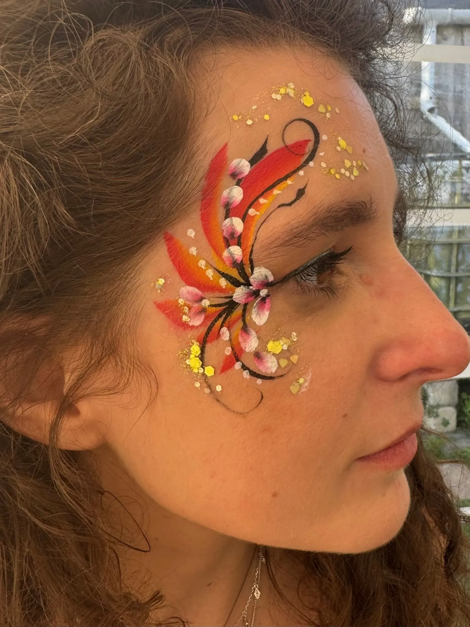 Woman with a red and gold phoenix eye design