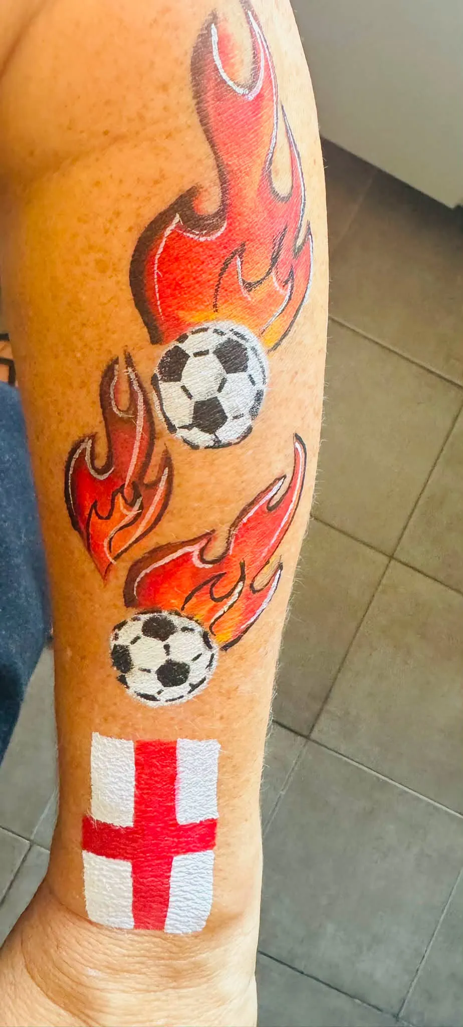 Flames, footballs and an England flag painted on an arm