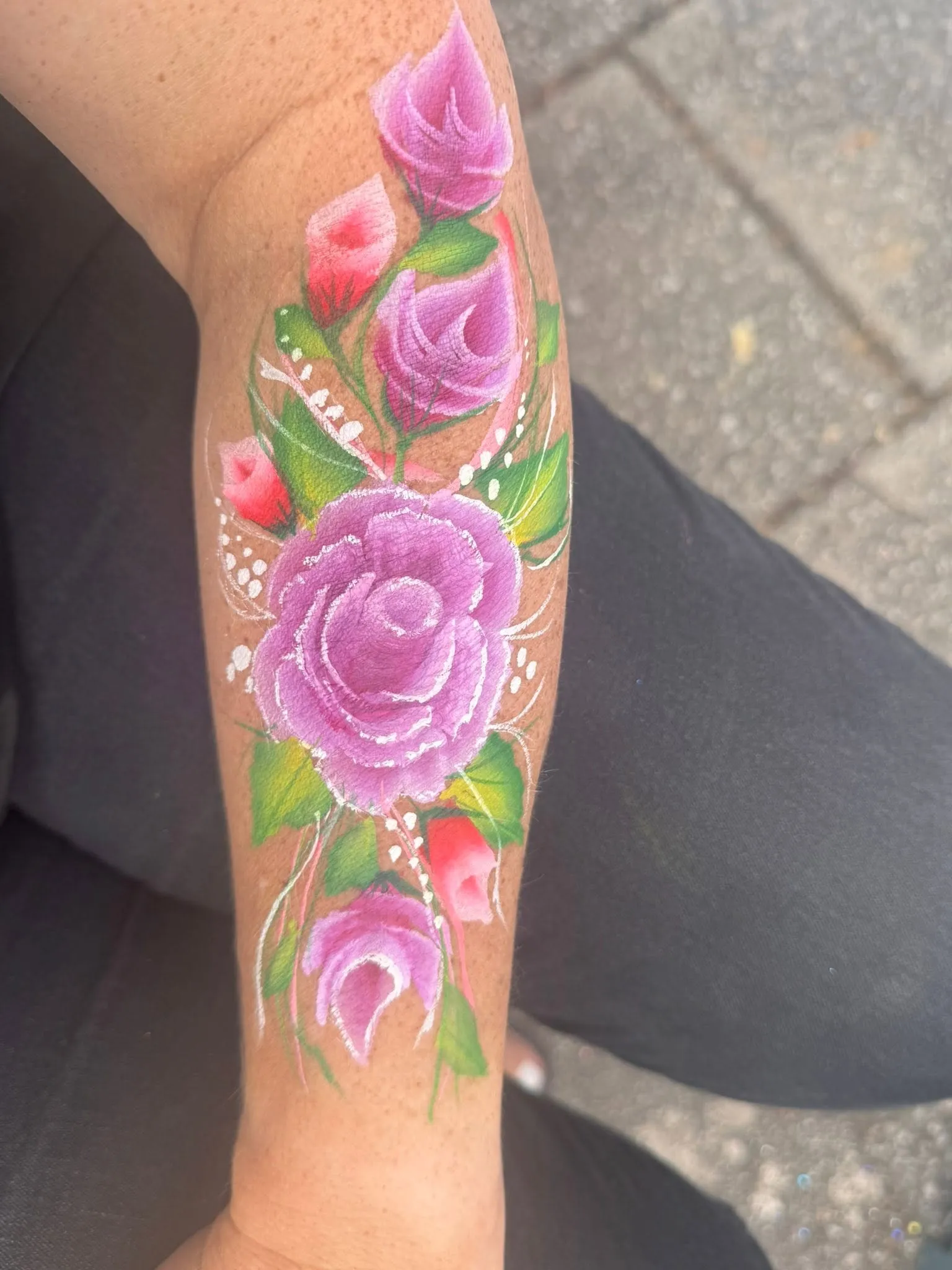 Painted pink roses running down an arm