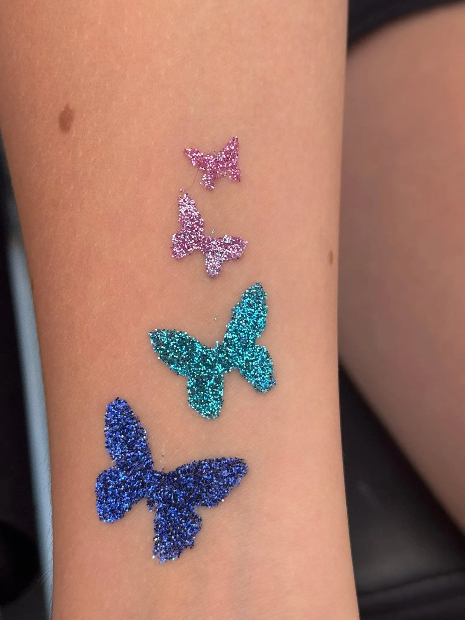 Blue glitter butterflies on an arm