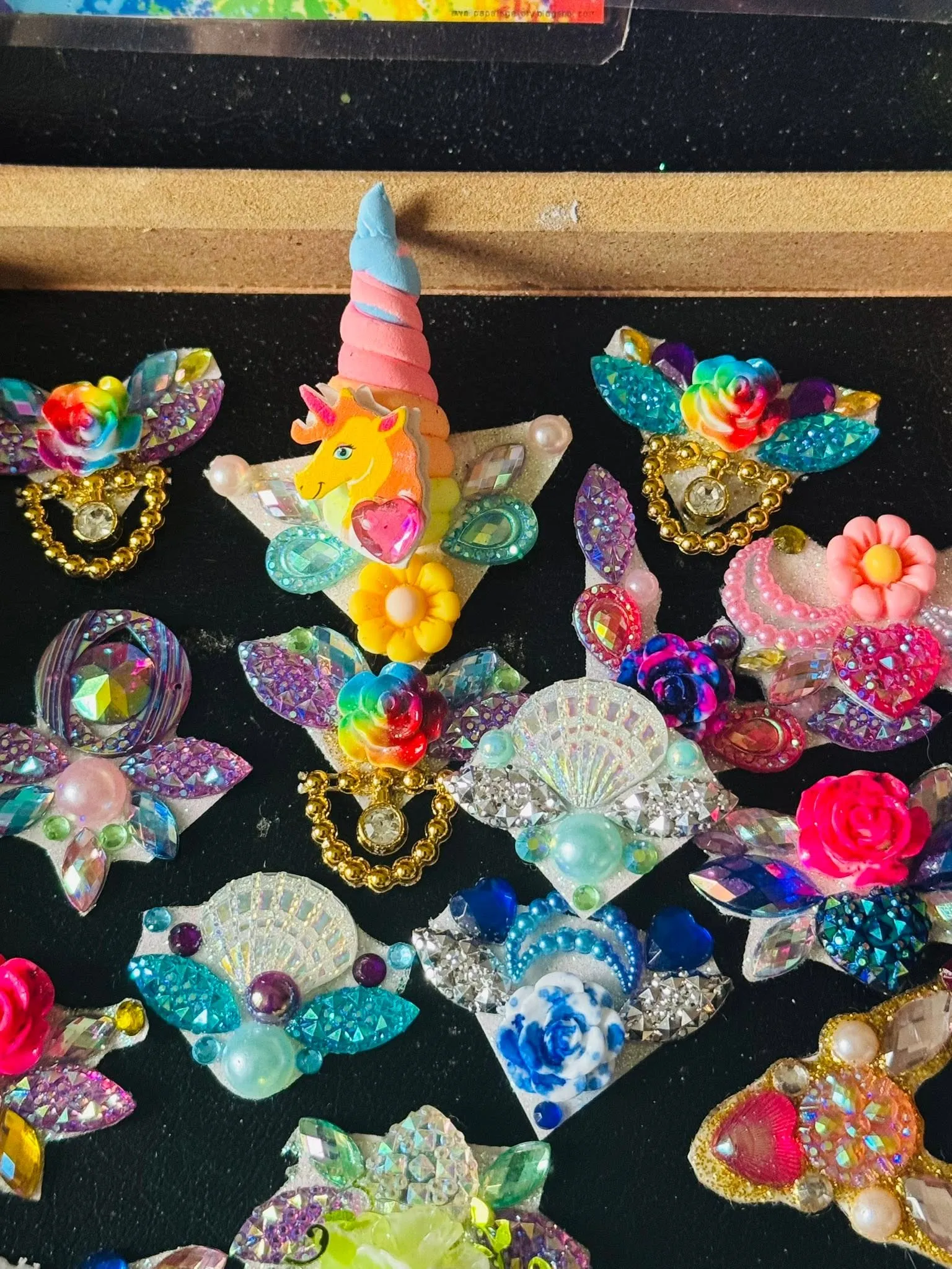 Handmade unicorn and flower gem clusters on black felt