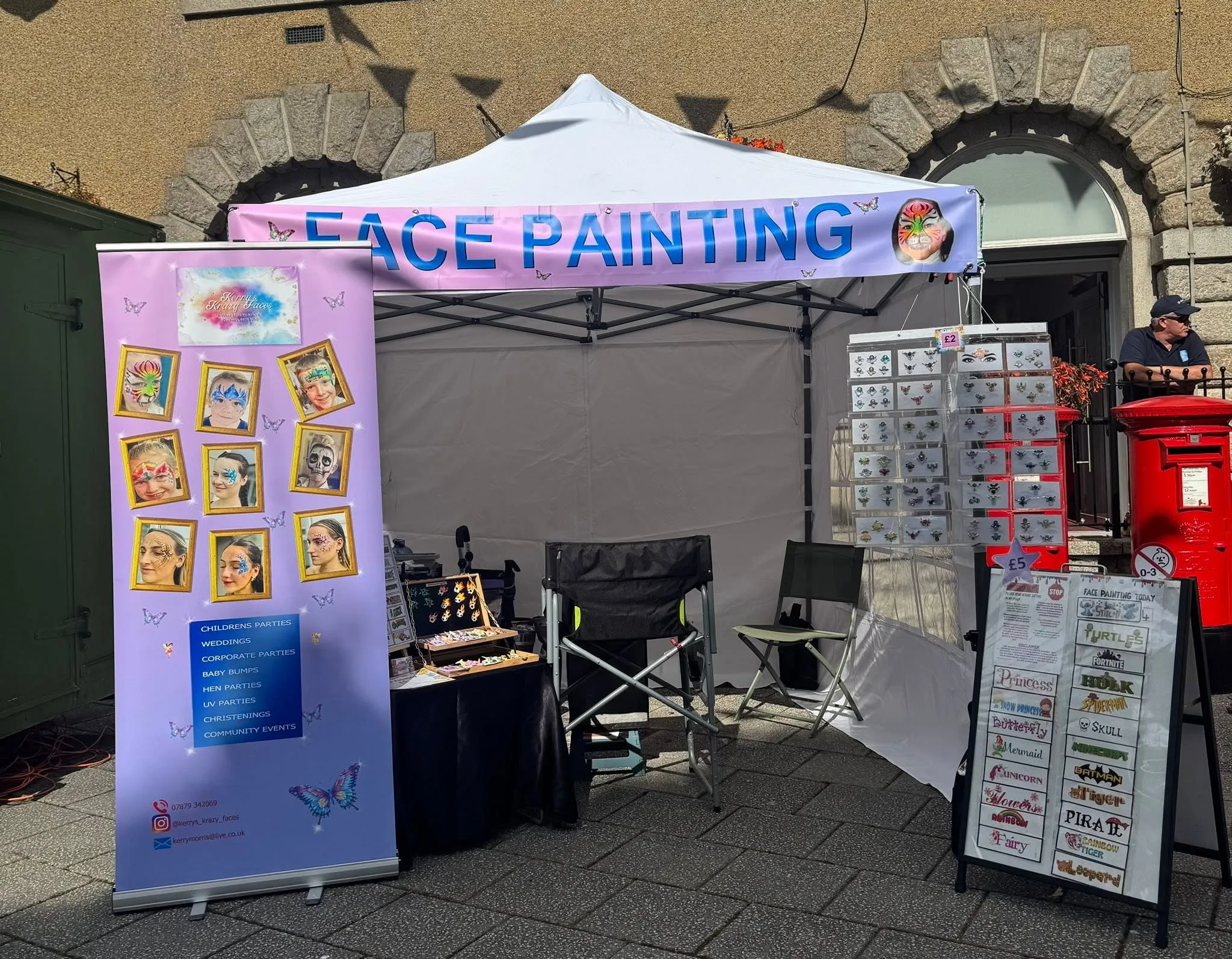 Kerry's face painting gazebo with her banner, gem rack and design menu board
