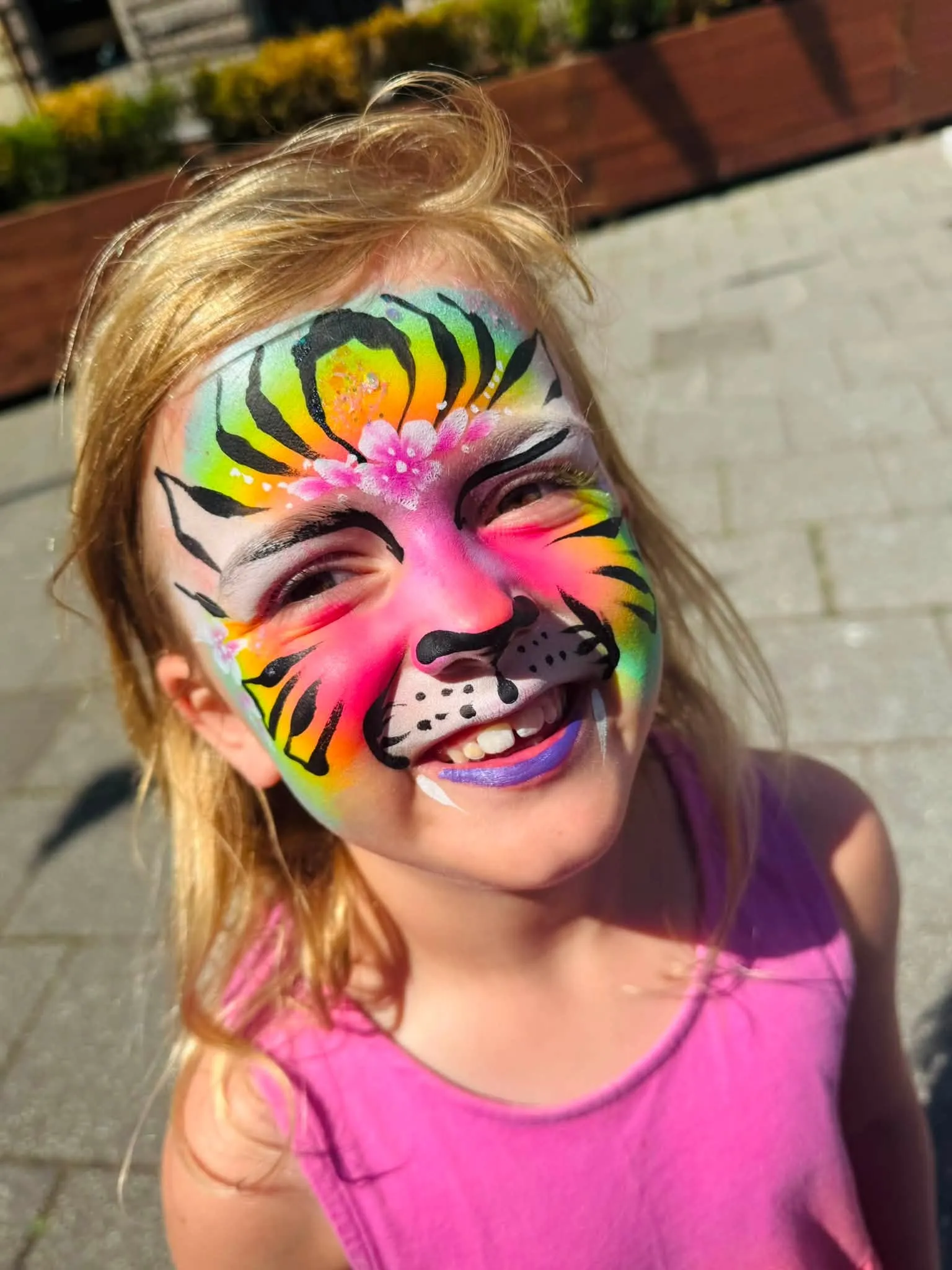 Girl with a bright rainbow tiger face