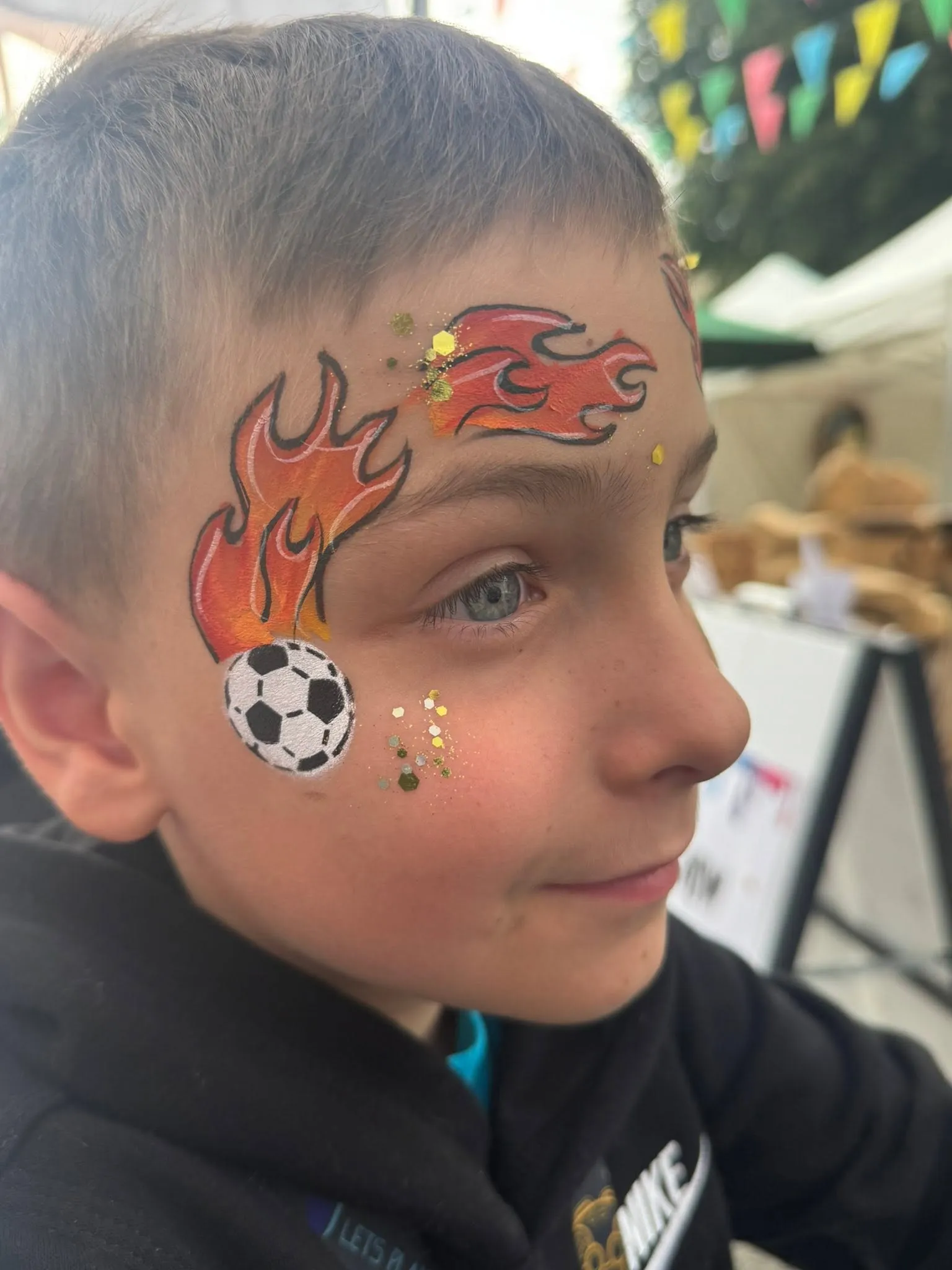 Boy with orange flames and a football on his cheek